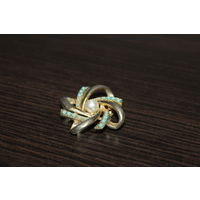 Металлическая брошь с пластиковыми бусинками.